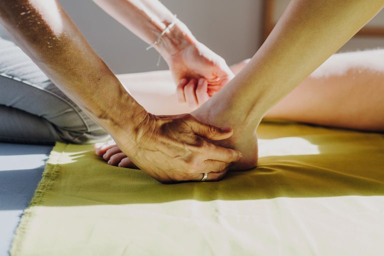 Physiotherapeutin behandelt Patientin am Fuß